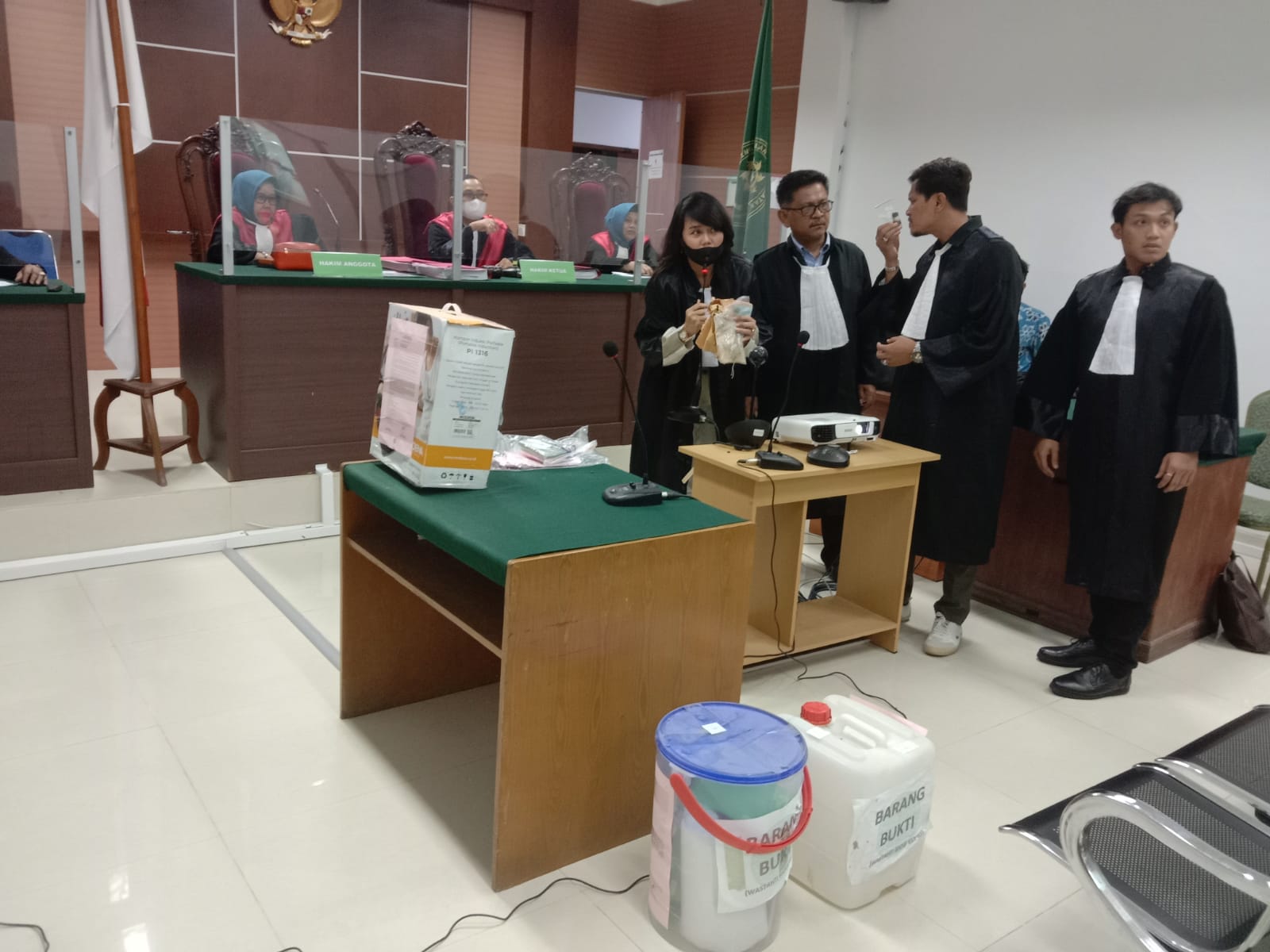 Indra Sakti sedang mencium barang bukti minyak yang diduga bahan baku pembuatan sabu-sabu. (Foto: JP - BATAMPENA)