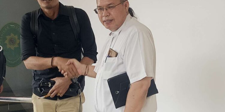 Advokat Hermanto Tambunan bersalaman dengan Advokat Niko Nixon Situmorang selaku penasehat hukum Roma Nasir Hutabarat. Keduanya saling ucapkan selamat usai kliennya divonis onslag vanrecht vervolging di PN Batam. (Sumber foto: JP - Batampena.com)