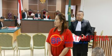 Terdakwa Nurmian Manalu meninggalkan ruang persidangan di PN Batam didampingi oleh penasehat hukumnya, Niko Nixon Situmorang. (Sumber foto: JP - BatamPena.com)