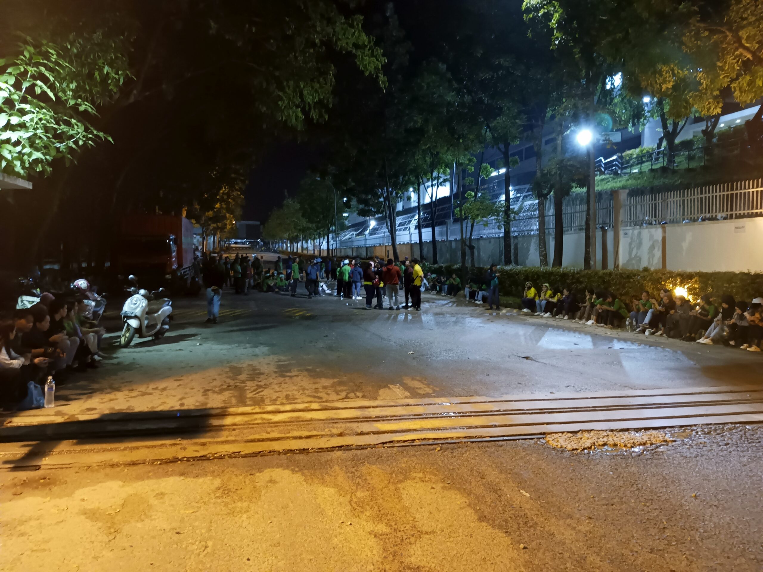 Para karyawan menunggu di titik kumpul karena kebakaran di PT WIK Far East.(Sumber foto: JP - BatamPena.com)